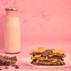 Stack of freshly baked Center filled chocolava cookies with visible melted chocolate and milk bottle in the background with pink background product photography