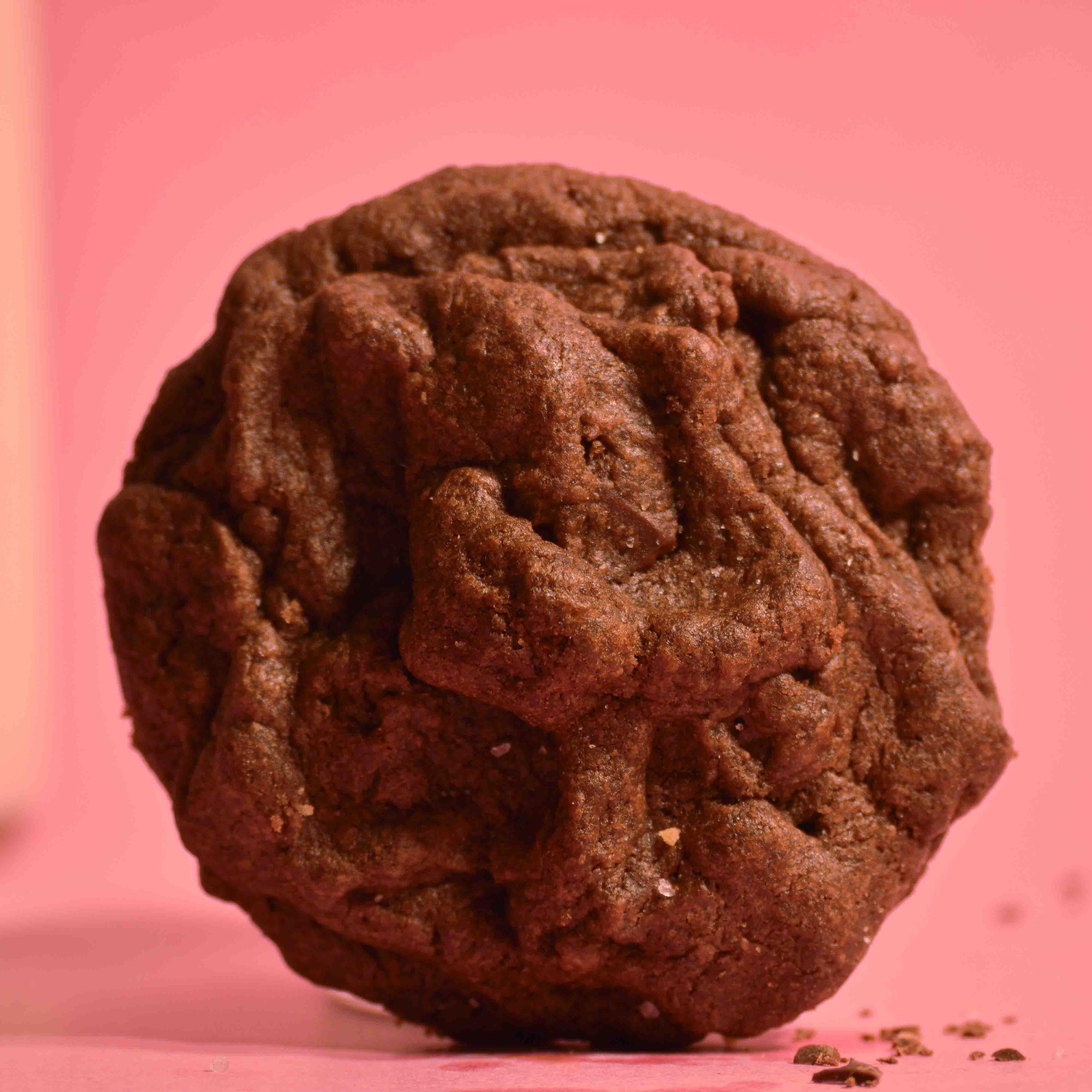 Petite Pleasure Double chocolate cookie, sea salt topping with soft gooey center on a pink background photography.
