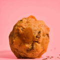 New York style cookie NYC cookie, with butterscotch toffee , sea salt topping with soft gooey center on a pink background photography.