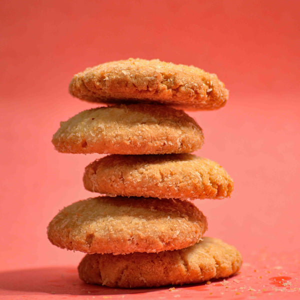 Coconut biscuit cookies crispy texture covered in coconut with Pink background stacked on top of each other professional product photography