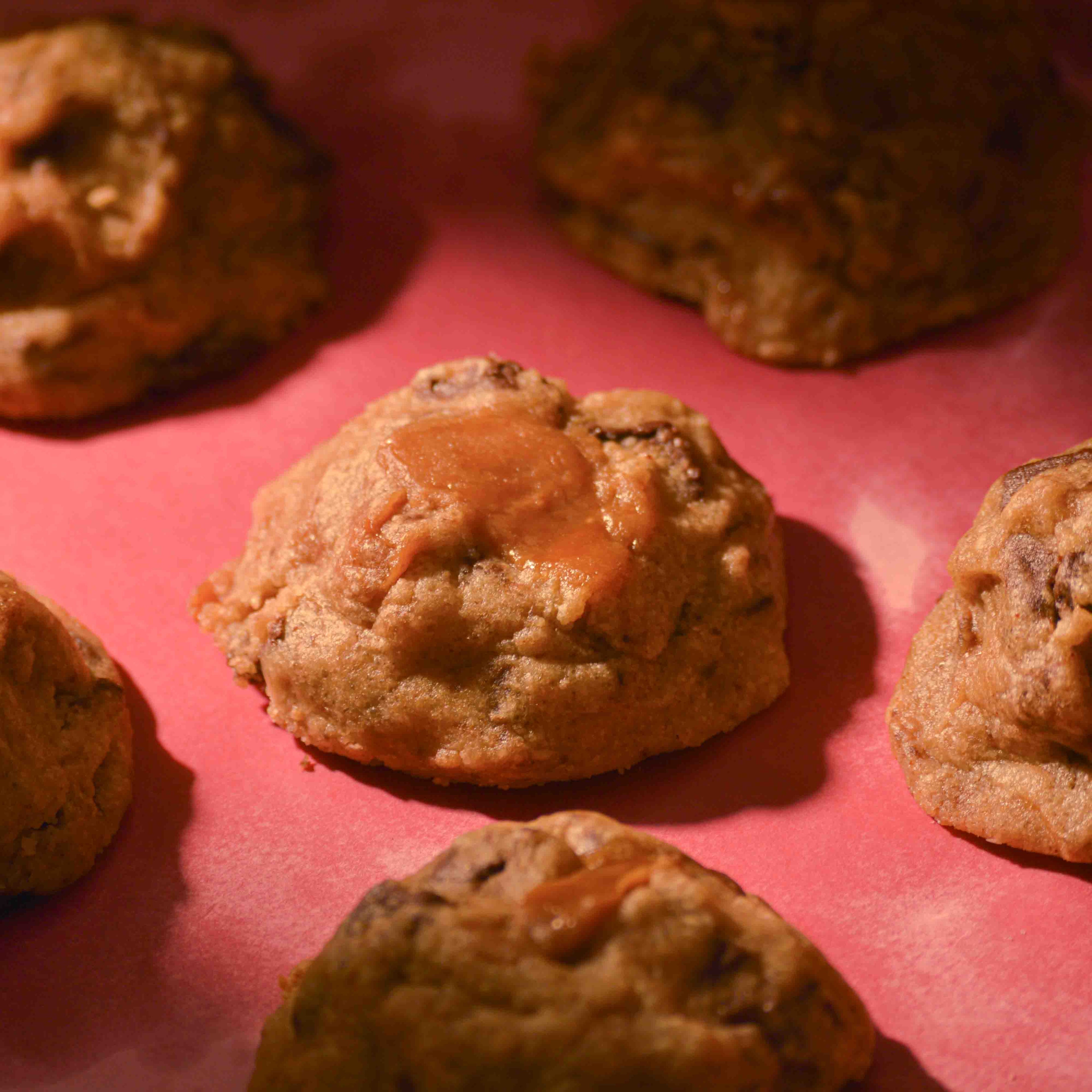 Thick NYC America choco chip cookies topped with sea salt gooey center and crispy edges on a pink background professional photography