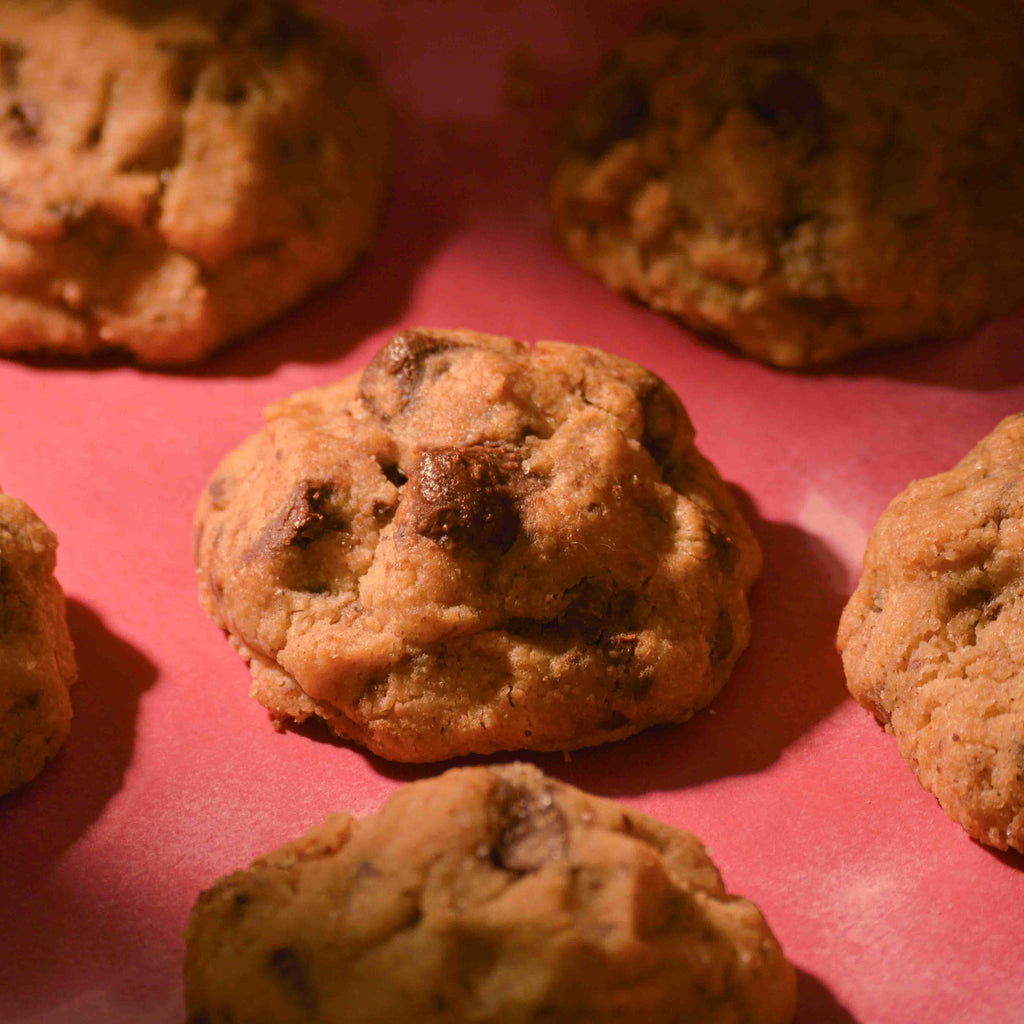 Thick Choco Chunk cookies topped with sea salt gooey center and crispy edges on a pink background professional photography